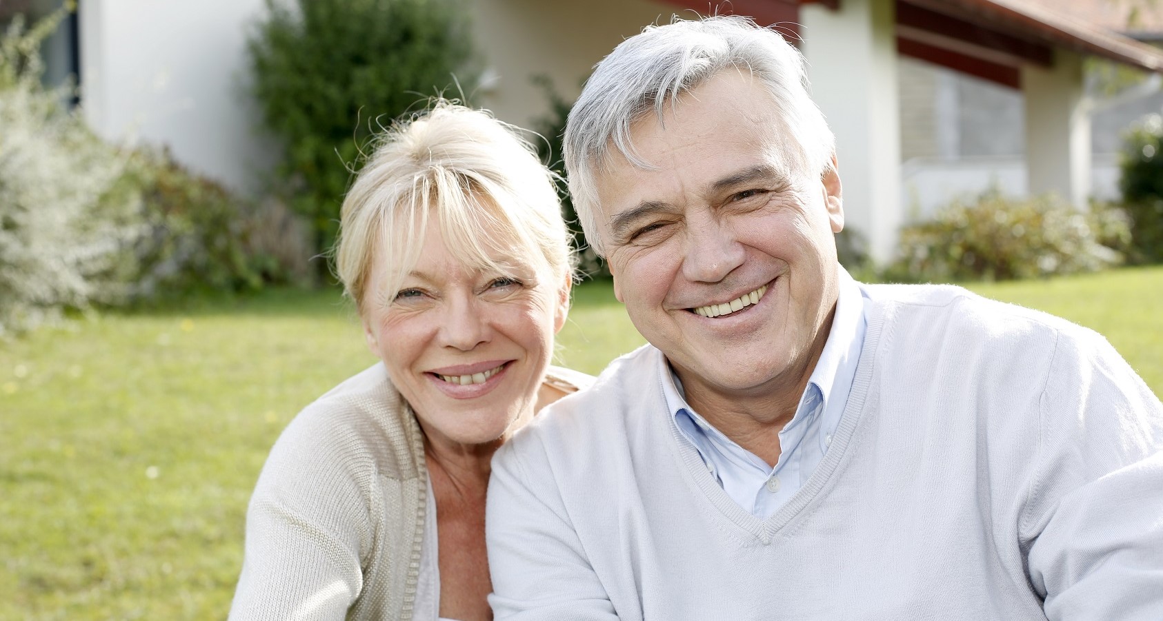 senior couple in front of house