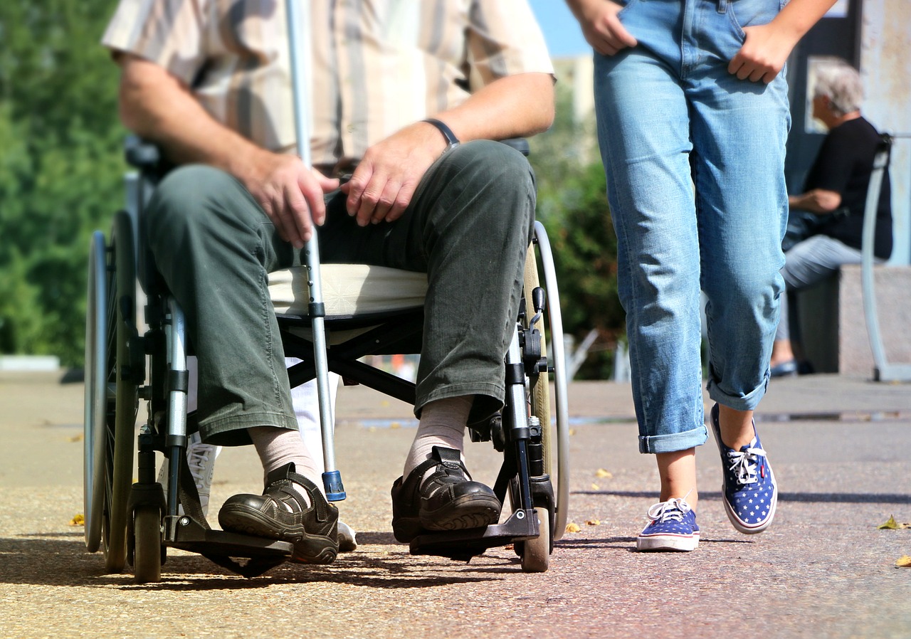 woman walking with older man in wheelchair