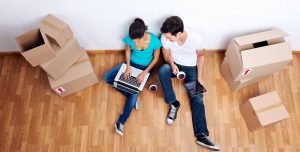 happy couple sitting on floor surrounded by boxes