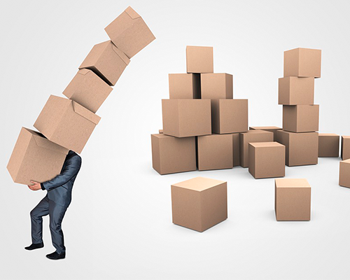 man carrying large stack of cardboard boxes