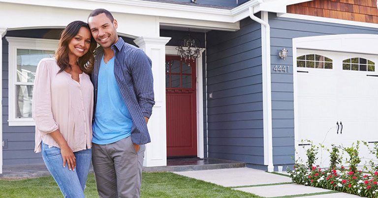 couple standing in front of home