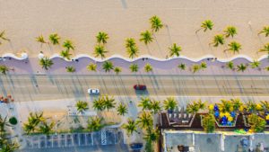 aerial perspective of cars driving along a beach highway