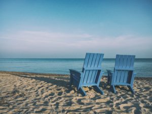 two blue chairs in miami florida sitting at the edge of the ocean on the beach