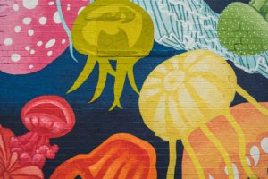 Colorful jellyfish mural painted over a brick wall