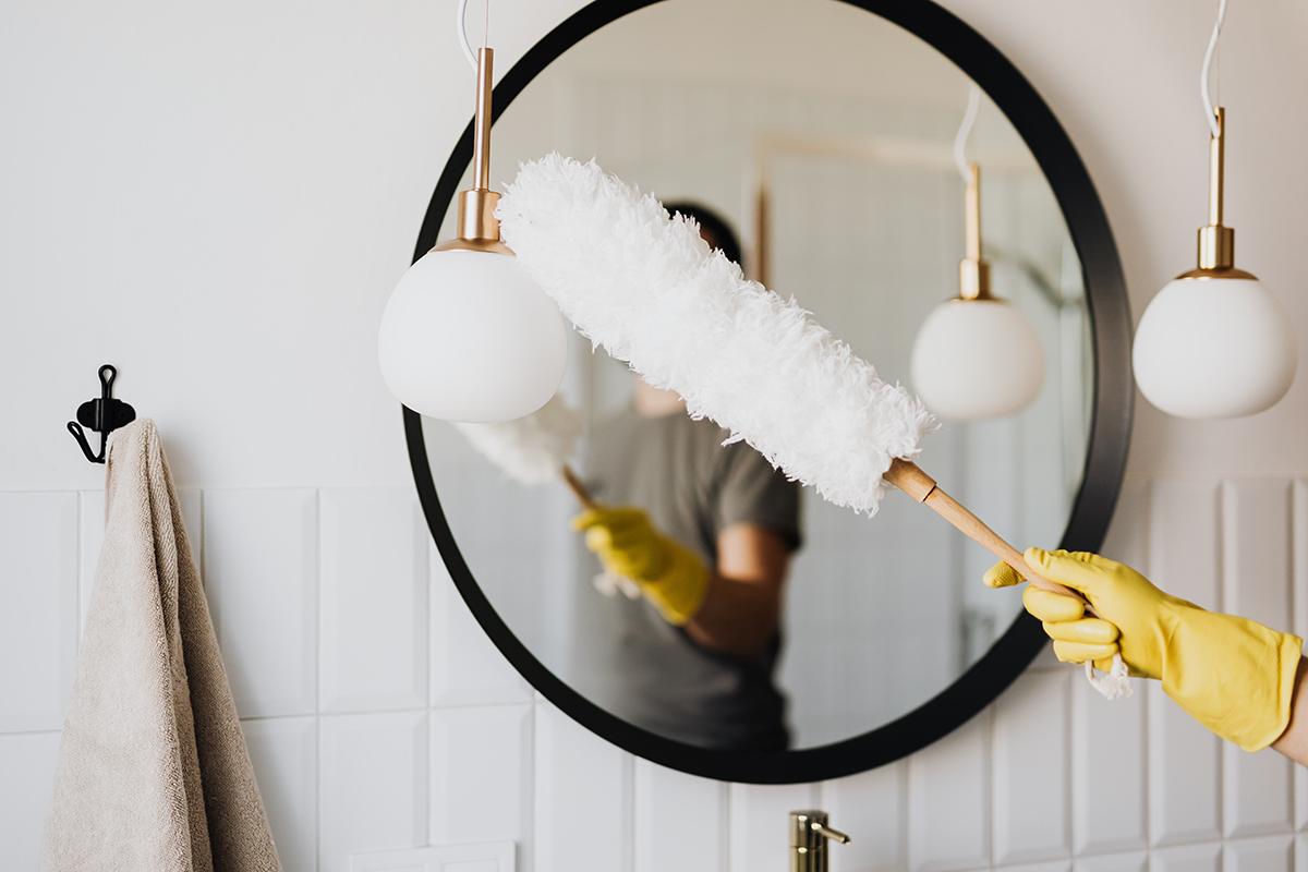 dusting a bathroom mirror for home staging